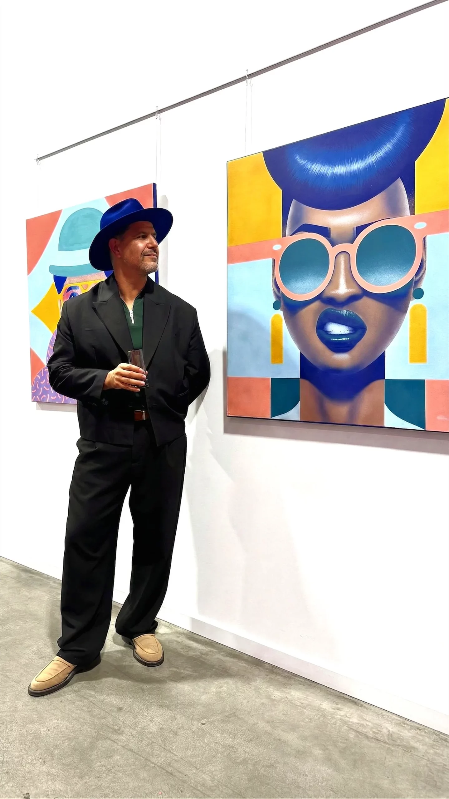 Samy Halim standing next to his pop art painting Victoria at an exhibition